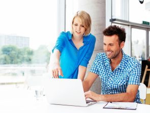 Young web designers looking at a laptop and discussing